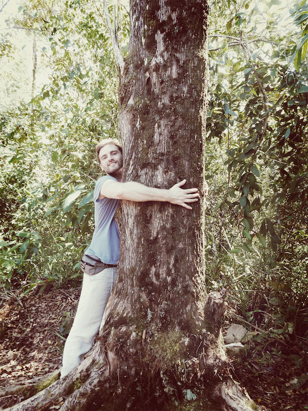 Hier ist das Vorstandsmitglied Arne beim Umarmen eines Baums zu sehen